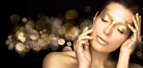 Gold based skincare concept. Beautiful woman face with gold mask. Cosmetology and spa treatment