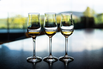 Three whiskey glasses containing single malt whiskey of different year and quality for tasting