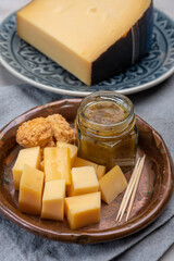 Cheese tasting, small pieces of old Dutch hard cheese and bowl with homemade dill-mustard sauce