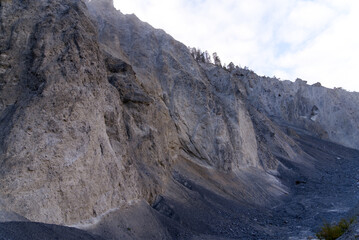 Cliff with cone of debris at canyon of Anterior Rhine Valley on a blue cloudy autumn morning at Versam, Canton Graubünden. Photo taken September 26th, 2022, Versam, Anterior Rhein valley, Switzerland.