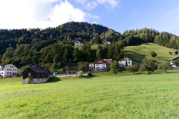 Scenic landscape with green hills and meadows at mountain village Versam, Canton Graubünden, on a blue cloudy autumn day. Photo taken September 26th, 2022, Versam, Safiental, Switzerland.