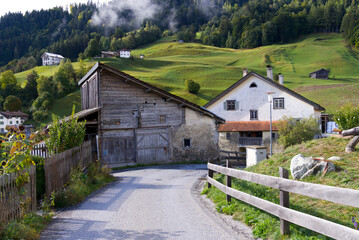 Scenic landscape with green hills and meadows at mountain village Versam, Canton Graubünden, on a blue cloudy autumn day. Photo taken September 26th, 2022, Versam, Safiental, Switzerland.