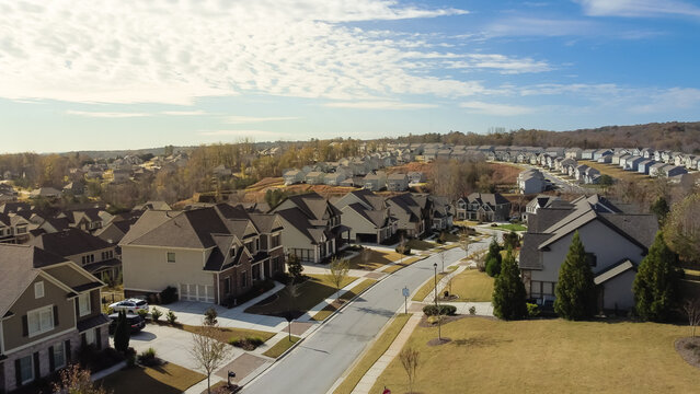 Quiet and peaceful residential street with row of new development two story single family houses rare sunny cloud sky formation in subdivision sprawl leads horizontal