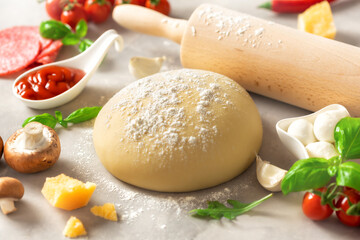 Fresh dough with set ingredients for cooking italian pizza on a white table