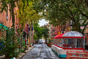 Greenwich Village beautiful street with restaurant outdoor seating, brick buildings, and gorgeous...