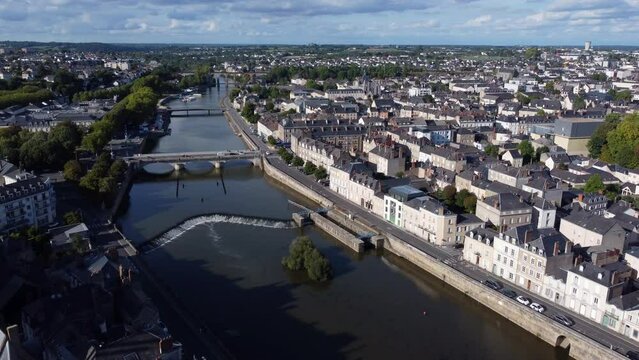 Aerial flying backwards over Mayenne River revealing Laval Castle, France