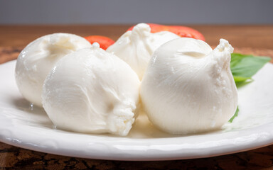 Eating of fresh handmade soft Italian cheese from Puglia, white balls of burrata or burratina cheese made from mozzarella and cream filling