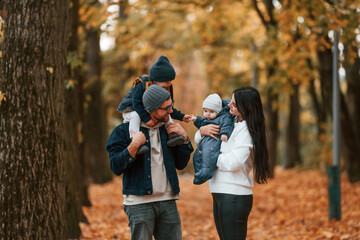 Father with his son on hands walking with mother that is with toddler