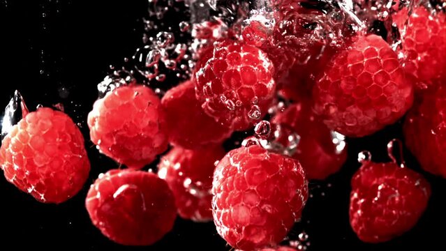 Fresh raspberries fall underwater with bubbles. Filmed is slow motion 1000 fps. High quality FullHD footage