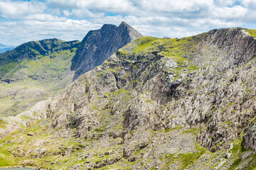 Climbing up Snowdon, mountains in North Wales. View of the hills and mountains, green grass and clouds, selective focus