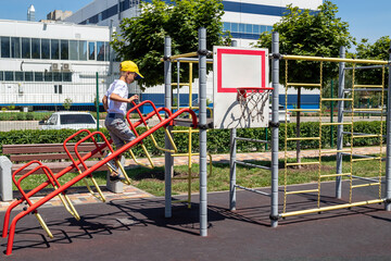 Boy climbs handrails, plays on playground. Healthy summer activity for children. Free time to play. Children's favorite activity. Selective focus.