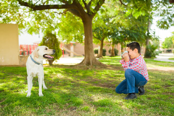 Cute kid playing with his happy dog at the park
