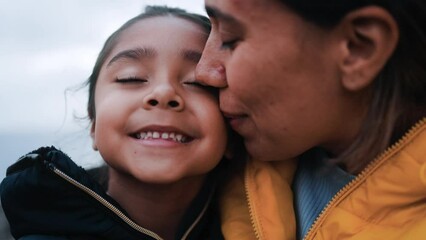 Happy latin mother and daughter having fun with outdoor in winter day - Family and love concept