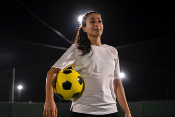 Portrait of female soccer player holding ball