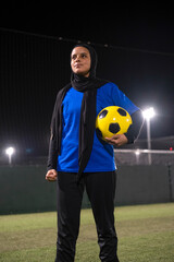 Portrait of female soccer player holding ball