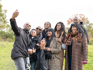 Portrait of?multi-generational?family taking?selfie?in meadow