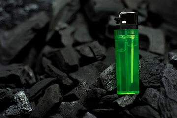 green lighter On a black background with charcoa