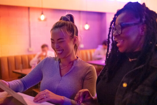 Laughing women looking at menu in restaurant