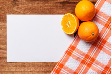 white paper with oranges checkered cloth on wood