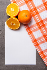 oranges with white checkered cloth sheet on dark marble background