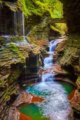 Magical waterfalls and gorge in Upstate New York with fall foliage and stone bridge path