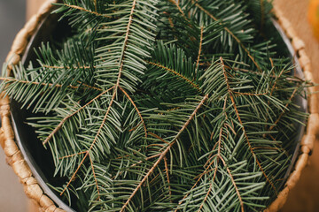 Pine branches in wicker basket.