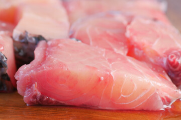 Fresh boneless skinless cod filet on chopping board 