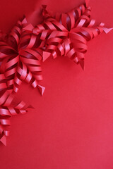 Festive red background for Christmas with red snowflake made of paper on selective focus with copy space