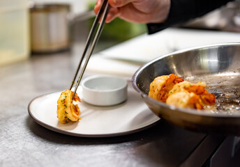 man chef cooking tasty shrimp on kitchen