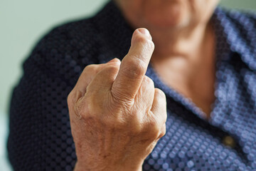 Elderly woman showing middle finger, scrooge you, fuck you - obrazy, fototapety, plakaty