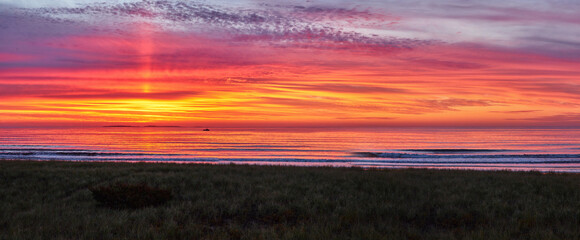 Panorama of Maine east coast beach during beautiful sunrise with golden light