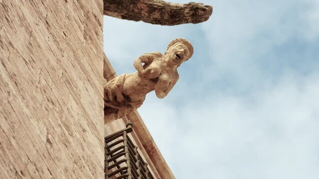 Erotic gargoyle on the Valencia Cathedral facade, medieval building in Spain
