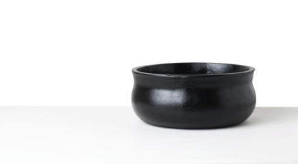 Empty black textured flowerpot on white table isolated on white or transparent background