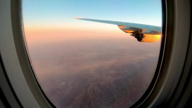 朝焼けの中ジェット気流を出しながら飛ぶ飛行機　中国上空
