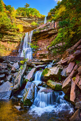 Obraz premium Stunning terraced waterfalls small and large from below over mossy rocks surrounded by New York fall foliage
