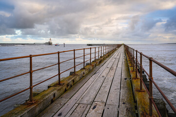 Obraz premium Wooden South Pier at Blyth Harbour, which lies about 7 miles north of Tynemouth and has had a very commercial recent past. It sits on the east coast of Northumberland in England