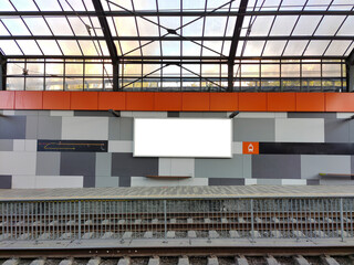 An empty white billboard hangs at an empty tram stop with a scrap for text. Mockup for advertising