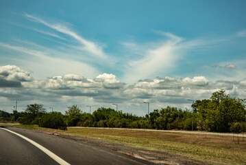 Campo al costado de la ruta con cielo nublado