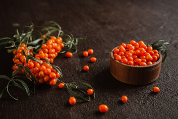 fresh sea buckthorn berries for healing spicy tea on black dark background 2