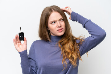 Young caucasian woman holding car keys isolated on white background having doubts and with confuse...