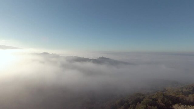 Tuscany hills sunset. Old castle on a mountain. Morning Fog