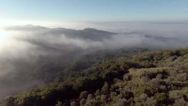 Tuscany hills sunset. Old castle on a mountain. Morning Fog
