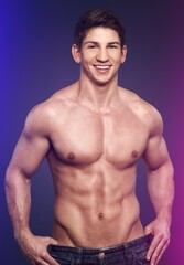 Fototapeta premium Sportive young male bodybuilder in neon light