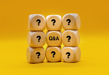 Wooden block with Q and A characters. The symmetrical surface of the table reflects the Q and A captions