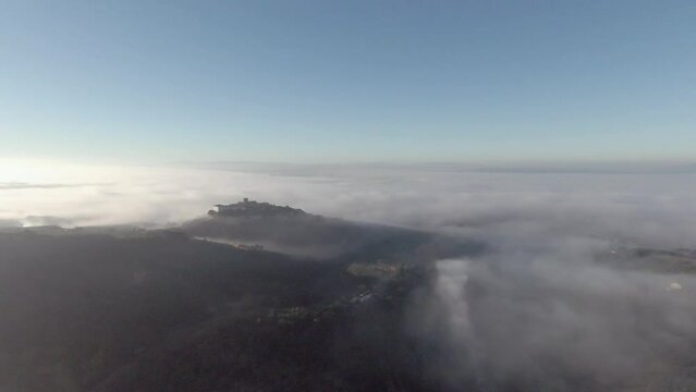 Tuscany hills sunset. Old castle on a mountain. Morning Fog