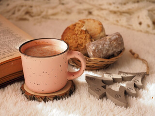 Cup of hot coffee with milk, Christmas polvorones, an old book.