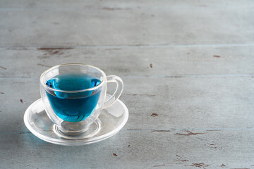 glass cup with blue Thai tea on a gray background