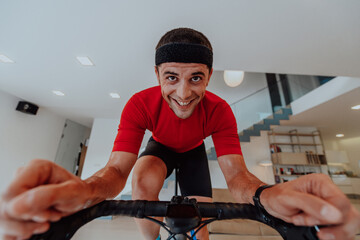 A man riding a triathlon bike on a machine simulation in a modern living room. Training during pandemic conditions.