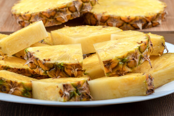 Closeup of sliced pineapple on a white plate.