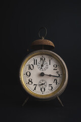 Old Vintage Alarm Clock set against dark background with copy space